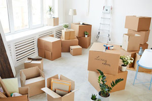 10 Packing And Moving Supplies You Need And How To Use Them Properly 1 Moving boxes, some taped and closed and others open sitting on the floor of a vacant, white colored living room